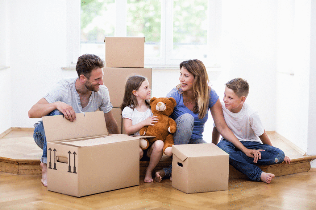 Auf diesem Bild ist eine glückliche Familie zwischen Umzugskartons zu sehen.
